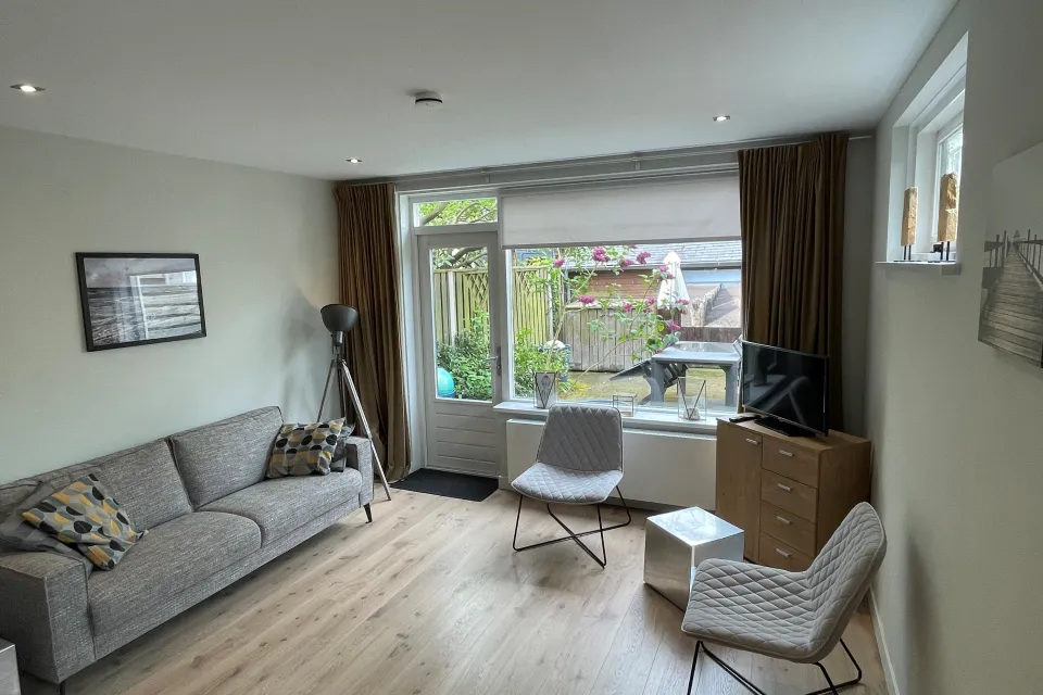 Woonkamer met 3 zits bank en 2 stoelen