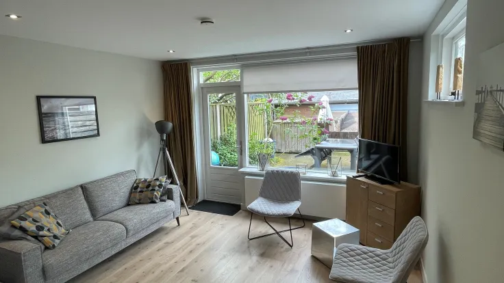 Woonkamer met 3 zits bank en 2 stoelen